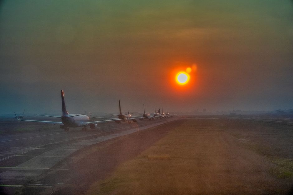 Silhouette of airplanes lined up on the runway at sunset in Banten, Indonesia.