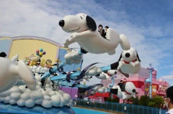 스누피 모양을 한 놀이기구에 사람들이 타 있다.