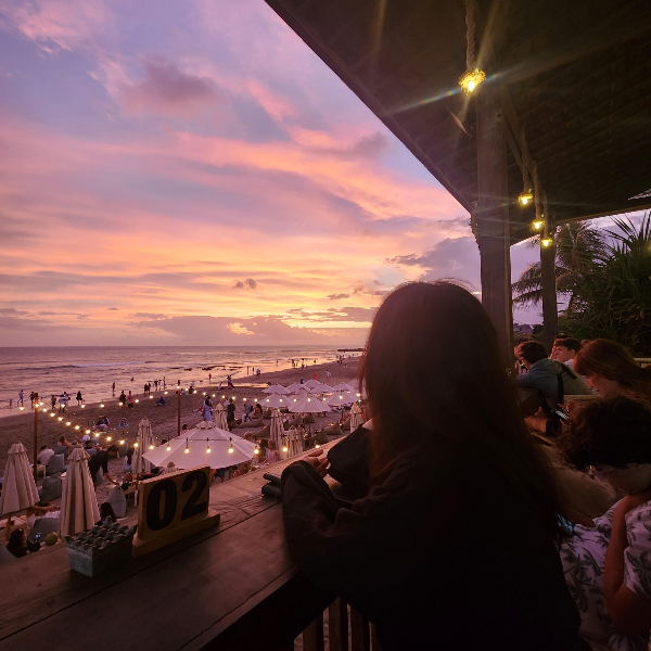노을진 바다 그리고 조명이 켜지기 시작한 해변 바에 사람들