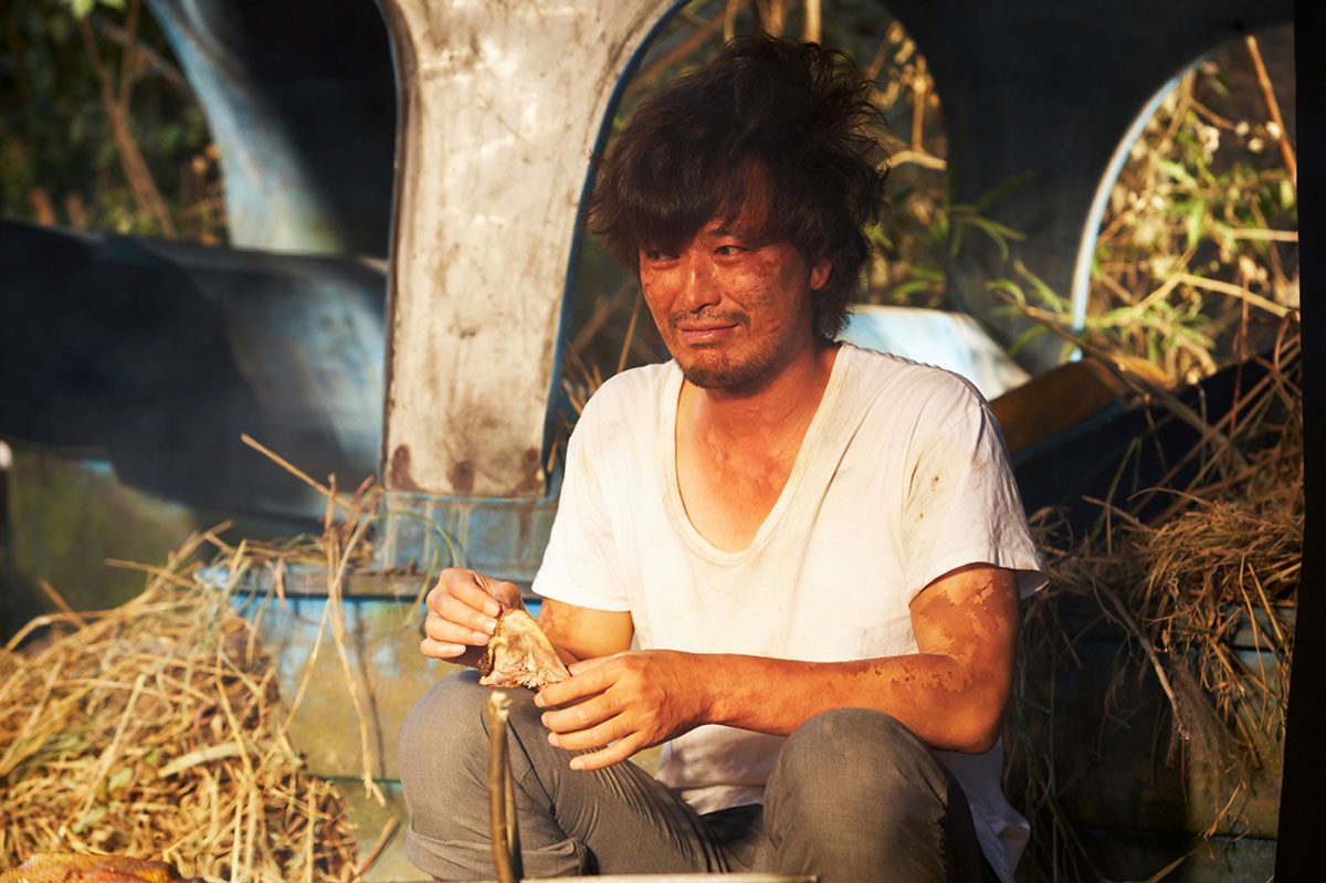 무인도에서 새를 구워 손에 들고 웃고 있는 김씨