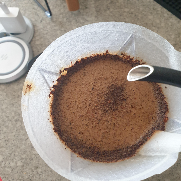 추가 푸어하는 모습. 추출 중인 드리퍼 위에 드립포트 수구가 보인다.