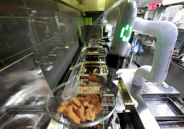교촌에프앤비가 지난 1월 가맹점에 조리로봇 시범 운영을 시작했다. 사진은 교촌치킨 다산신도시1호점에 도입된 조리로봇이 튀김 및 성형작업을 선보이는 모습