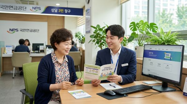 한국의 국민연금공단 사무실에서 임의 가입에 대해 상담을 받고 있는 50대의 한국인 여성. 30대 한국인 남자 직원이 PC와 국민연금공단 가이드북을 보며주며 친절하게 상담을 하는 한컷 만화 형식의 이미지. 배경에는 은은한 자연광이 들어오는 창문과 초록색 화분이 배치되어 신뢰감과 안정감을 주는 구도.