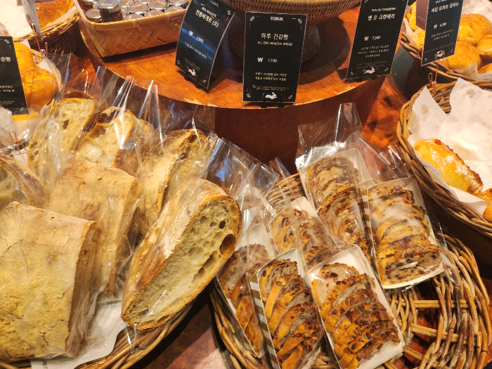 Baguettes and grain bread are in a basket.