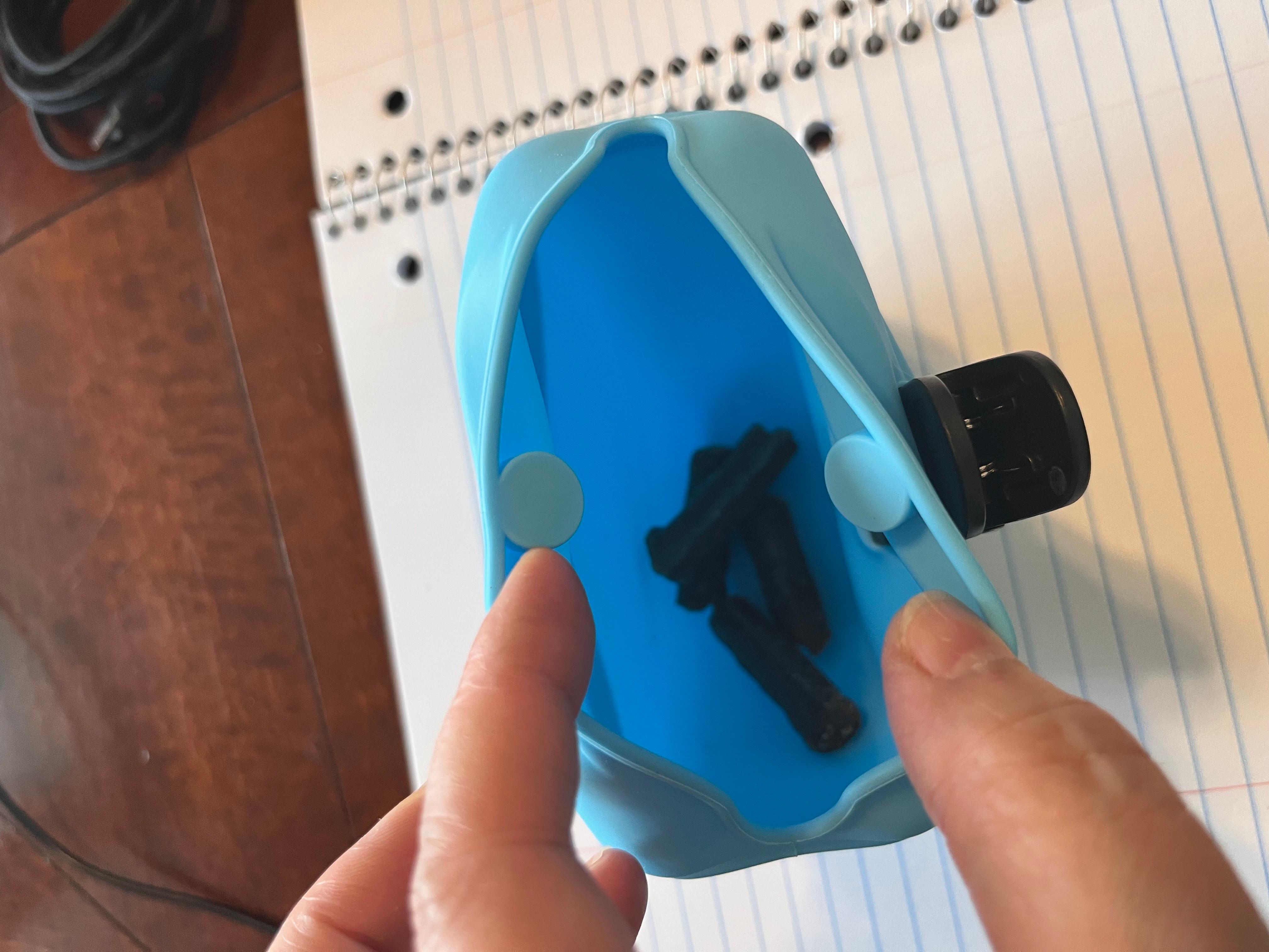 하늘색 실리콘 트릿 파우치 안에 강아지 간식을 넣고 보여주는 이미지