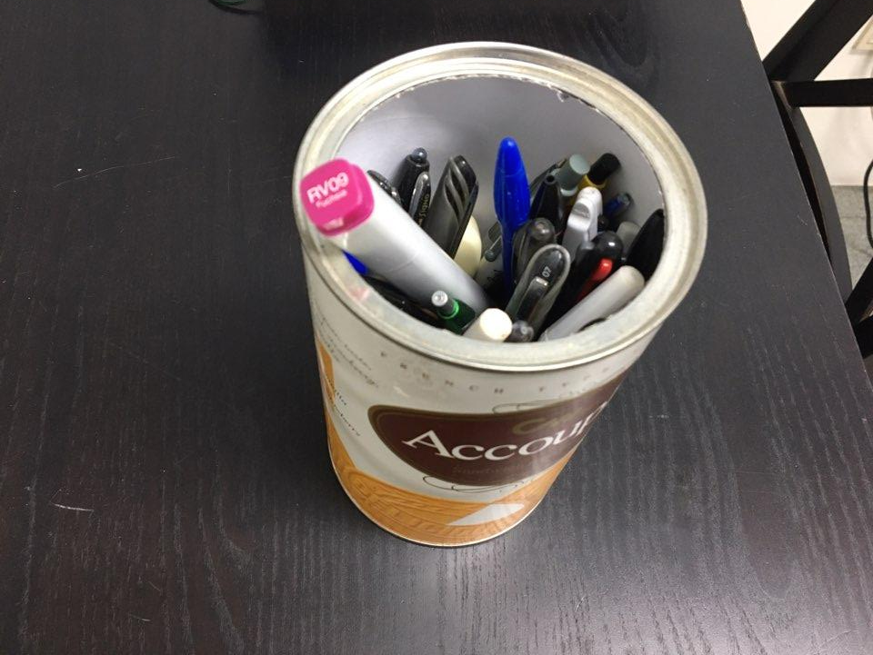 과자통을 재활용해 만든 연필꽂이에 다양한 볼펜과 펜이 가득 담긴 모습