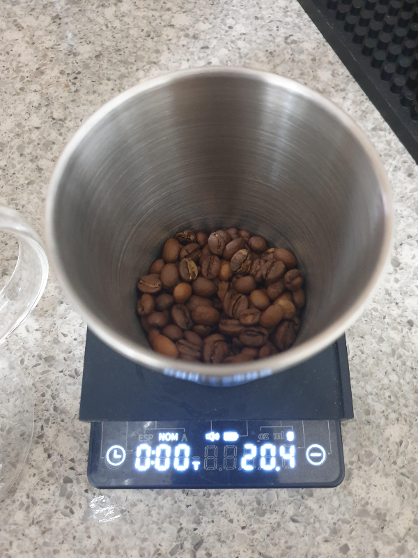 저울 위에 원두 20g이 담긴 컵이 놓여있다.