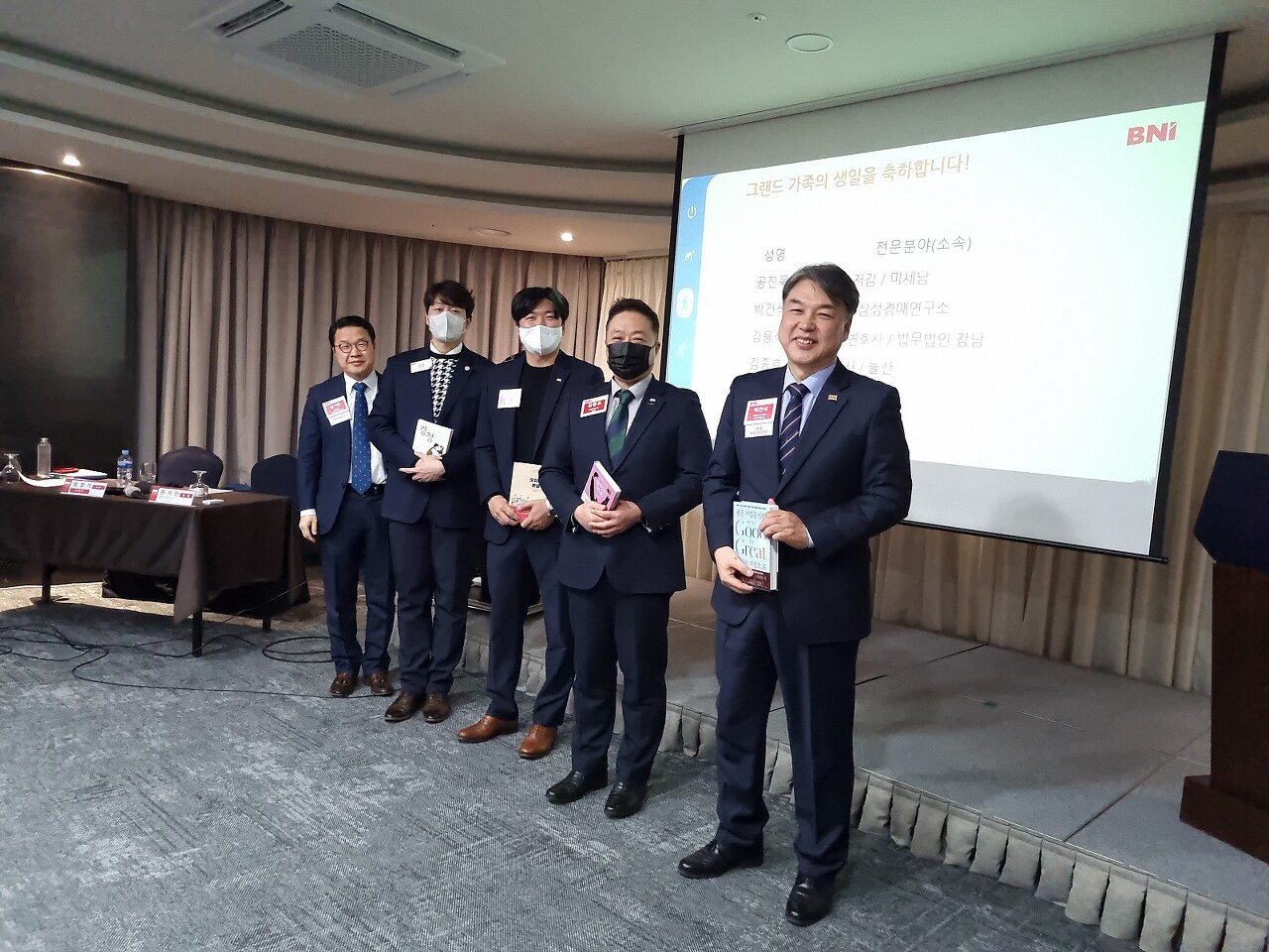 비엔아이 그랜드챕터 주간회의시 미세남 공진욱 디렉터님&#44; 형사 전문 변호사 김용석변호사님&#44; 분양대행사김종호대표님&#44; 법원특수경매 박건식대표님의 1월 생일자 축하선물 책을 들고 기뻐하는 모습입니다.