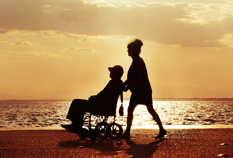 노인 휠체어 끌어주는 사진