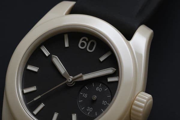 빛을 반사하며 윤기를 드러내는 매끄러운 베이지색 세라믹 시계 케이스