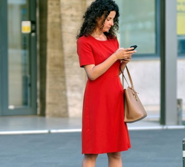 도로를 걷다가 핸드폰 문자를 확인하는 중년여성 사진