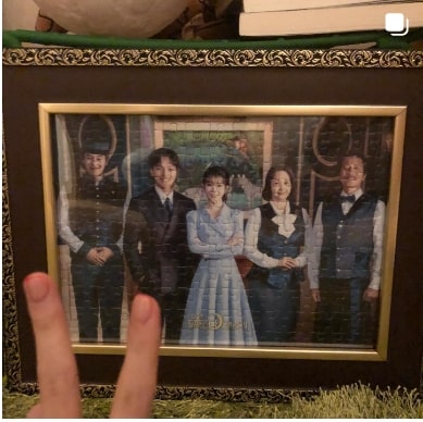 호텔 델루나 퍼즐 앞에 V자를 그리고 있는 아이유 손가락