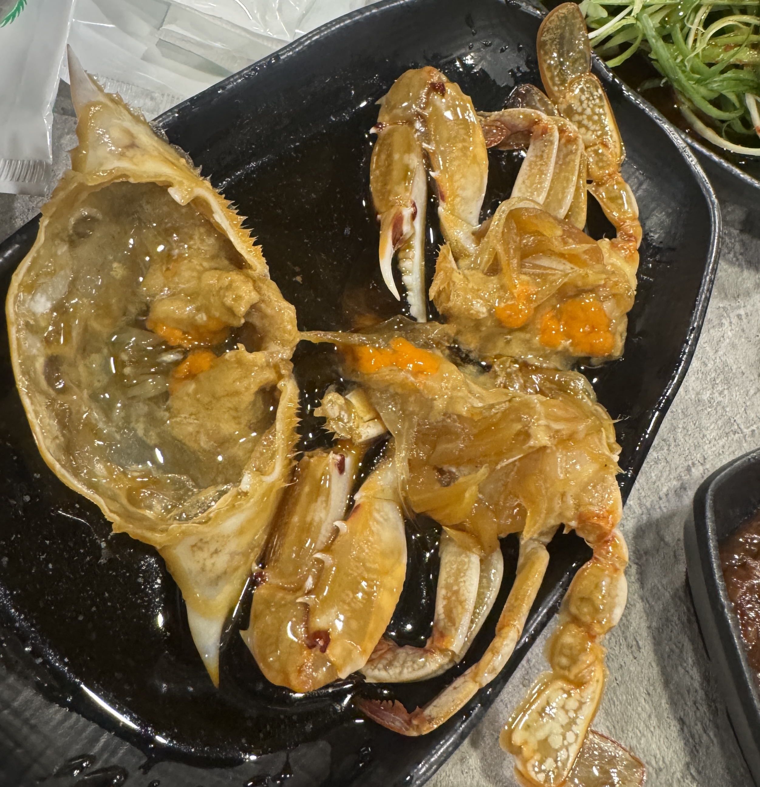 삼거리 명품한우에서 제공된 간장게장. 껍질이 얇고 알이 적당히 차 있는 신선한 간장게장이 검은 접시에 담겨 있다.