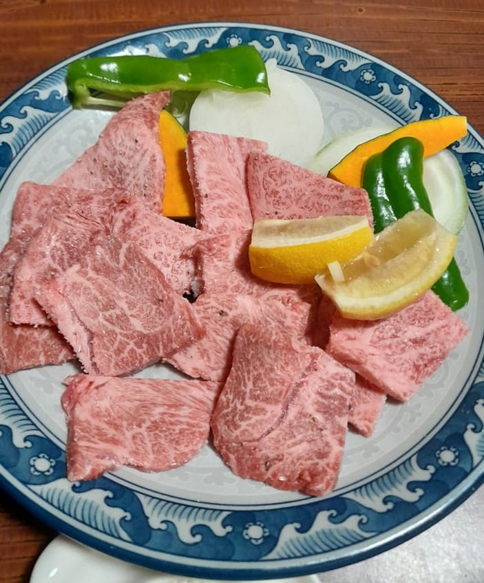 접시위에 갈비살들과 레몬 그리고 야채들이 있다