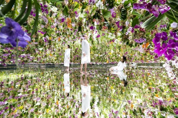 사람 3명이 서 있고 주변으로 온통 꽃들이 놓여져 있다.