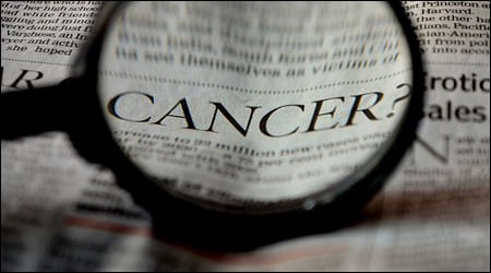 돋보기로 신문 속 cancer 단어를 확대