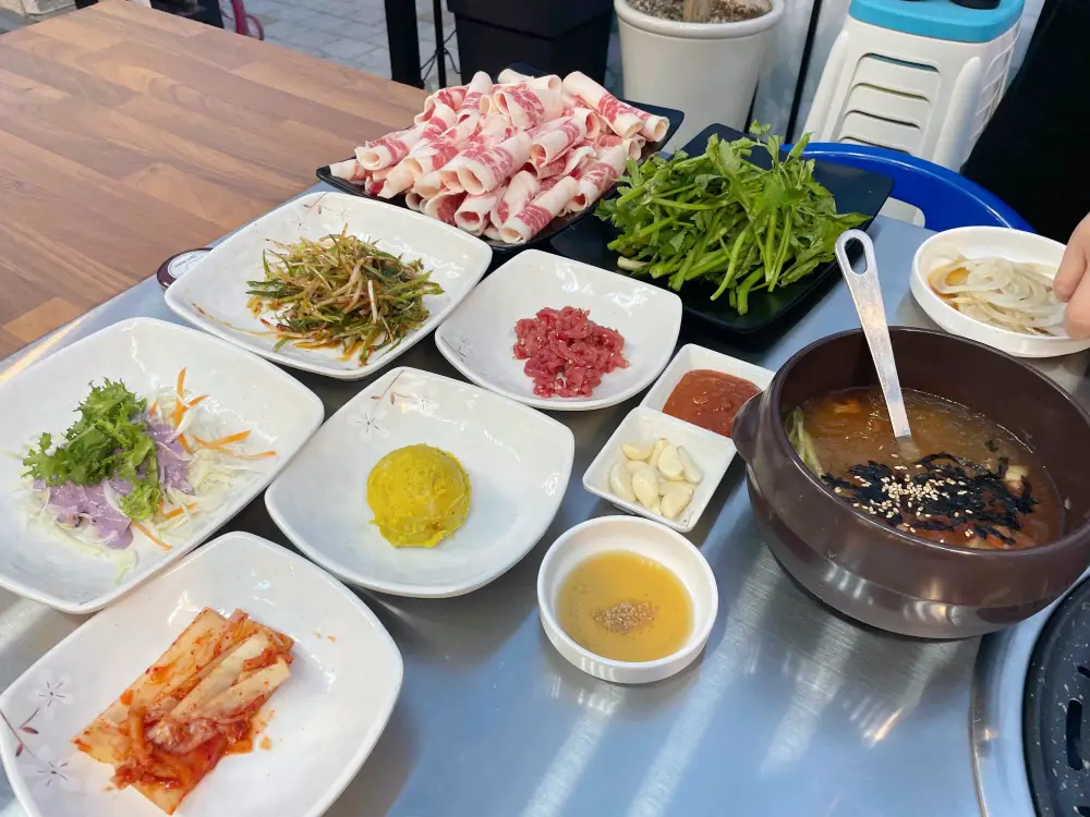 미나리와 차돌박이 각종 반찬과 육회들이 나온모습