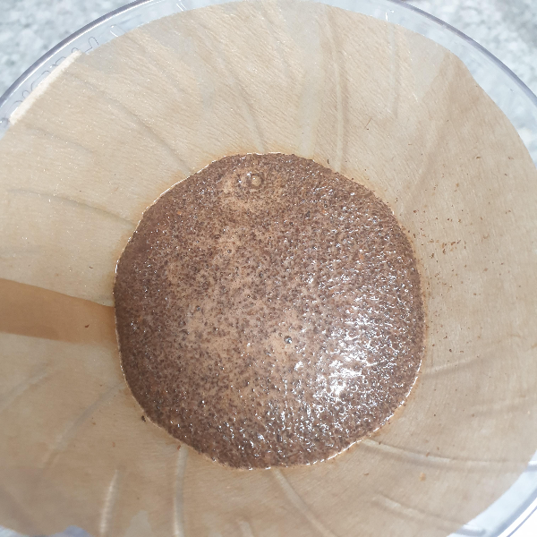 드리퍼에 부풀어 오른 원두가 담긴 필터가 밀착되어 있다.