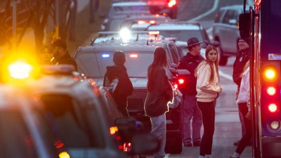 Students are escorted from a church next to the Abundant Life Christian School and loaded on busses to be taken to a reunification center in Madison, Wisconsin.