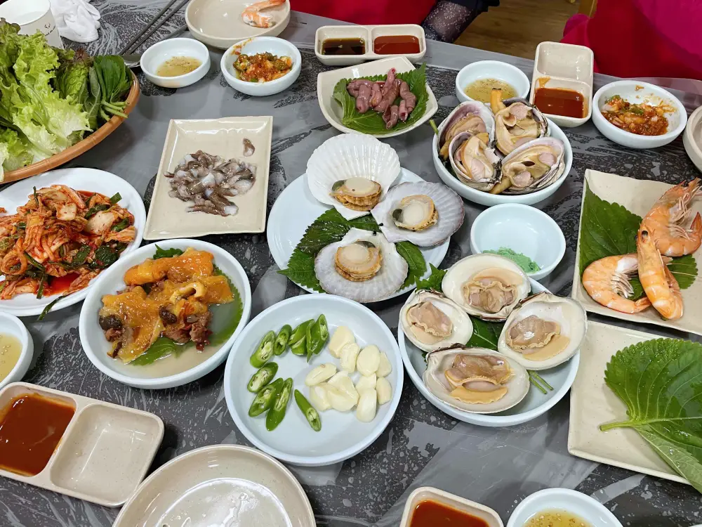 접시에 멍게 낙지 조개등이테이블위에 올려져 있는 모습