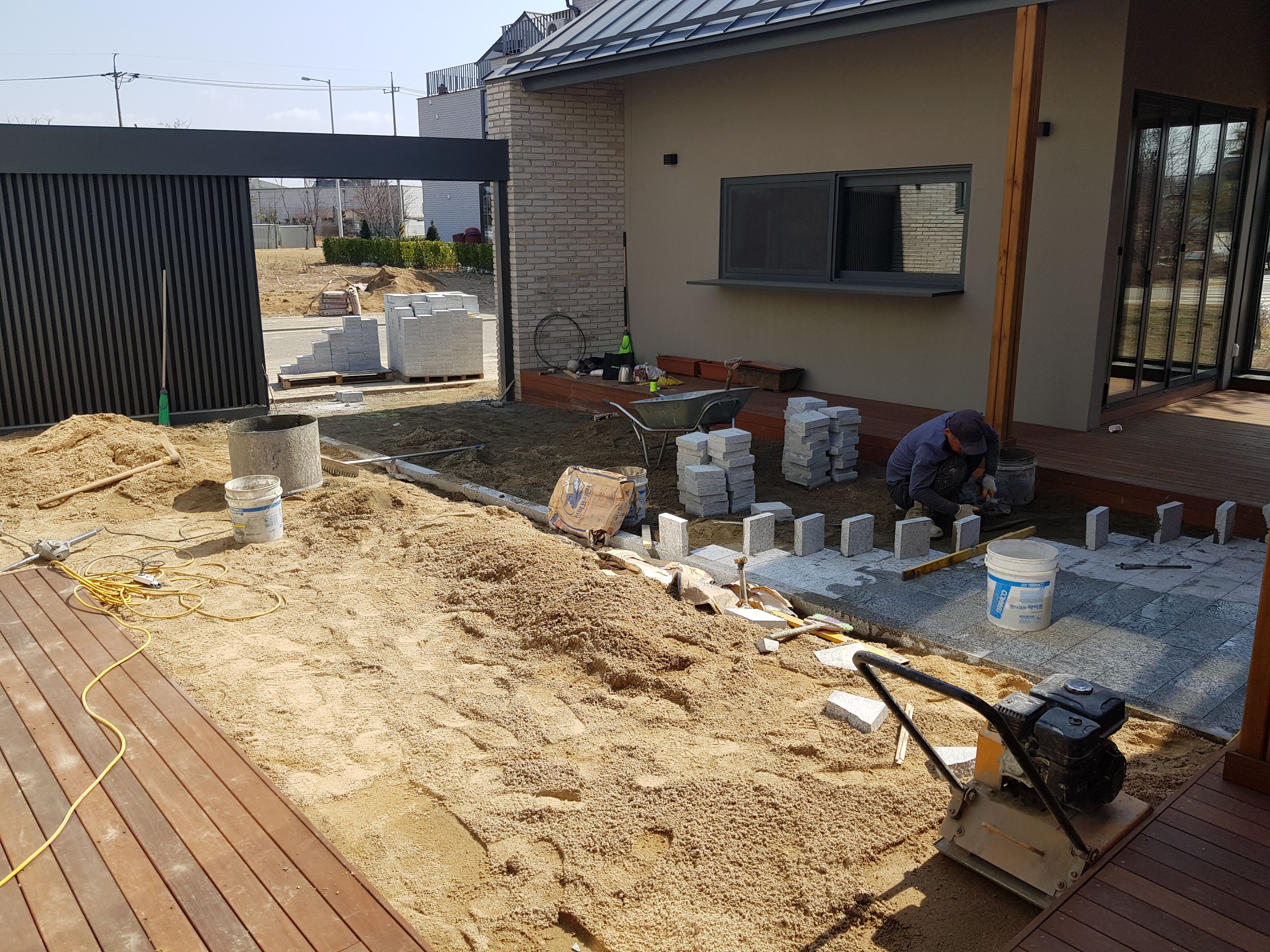 마당에 절반을 투수블럭을 깔고 절반에 잔디를 깔고 있는 모습