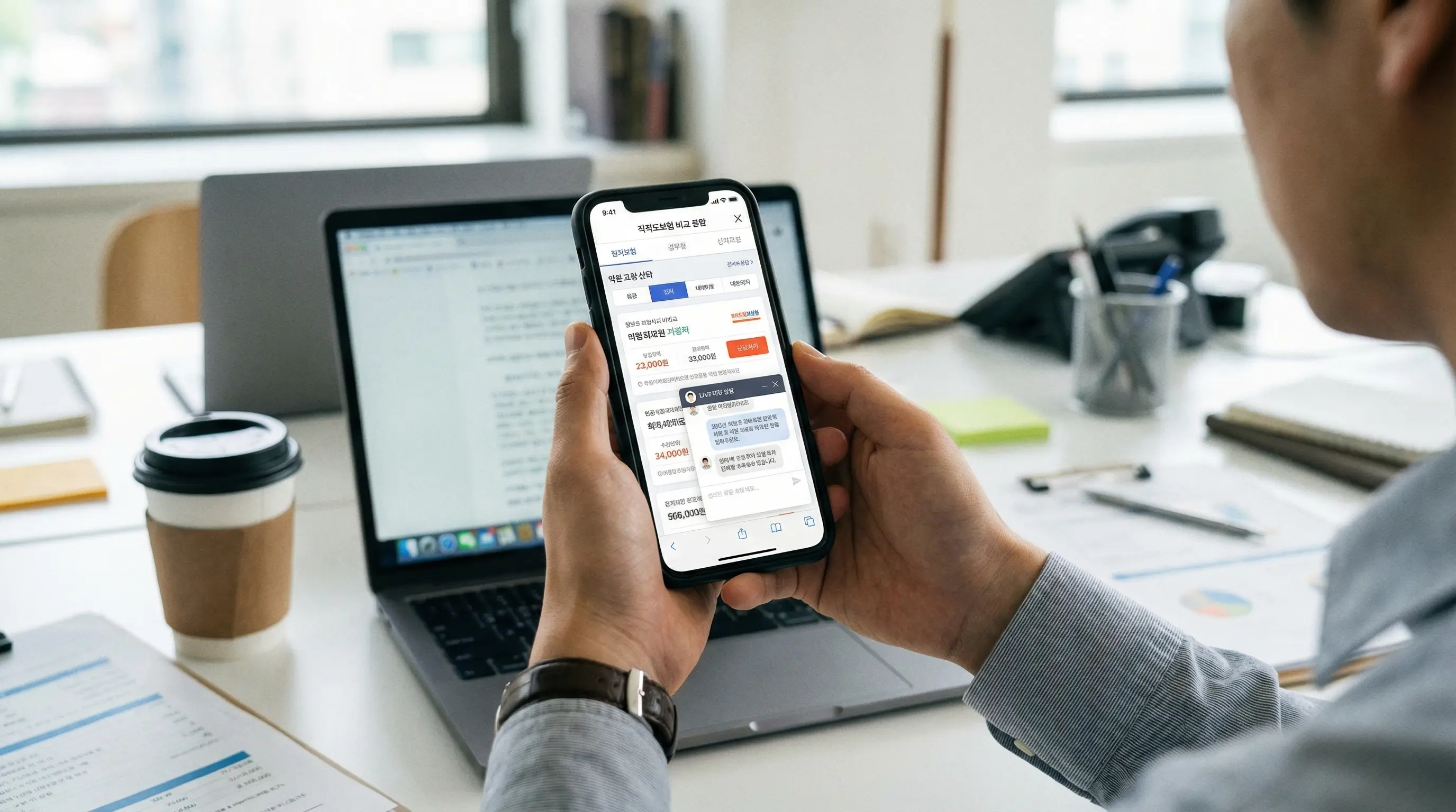 스마트폰으로 다이렉트 보험료를 비교하고 상담받는 직장인의 손