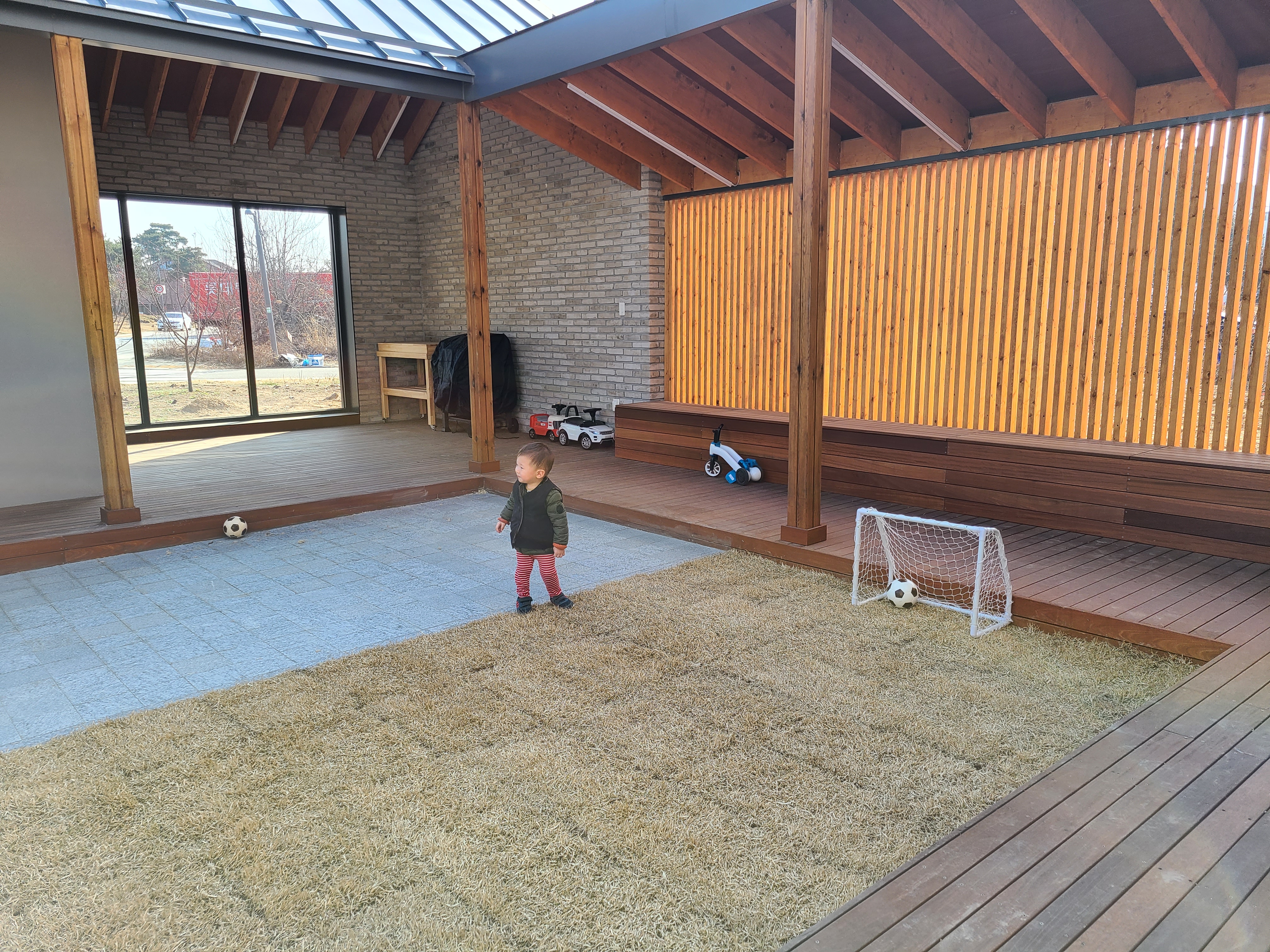 단독주택의 큰 마당에서 아이들이 축구를 하고 있는 모습