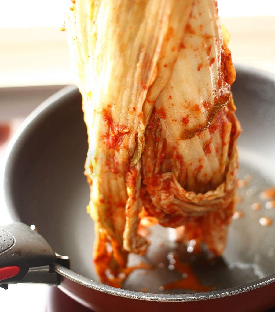 김치찌개 조리를 위해 웍에 김치 한 포기를 넣는 모습, Placing a whole aged Kimchi into a cooking wok