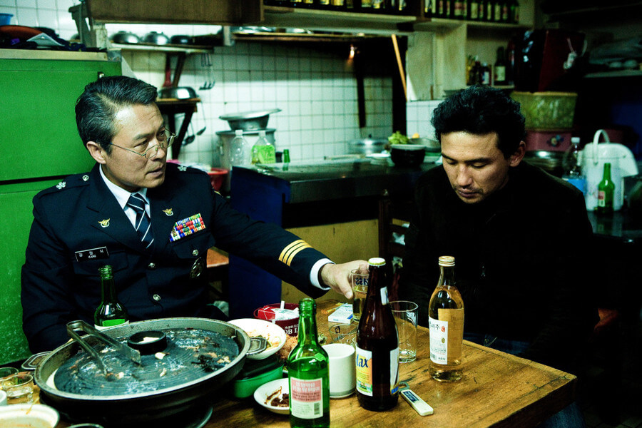 부패한 경찰 조직의 우두머리 강정식 국장과 그의 술을 받고 있는 최철기 형사