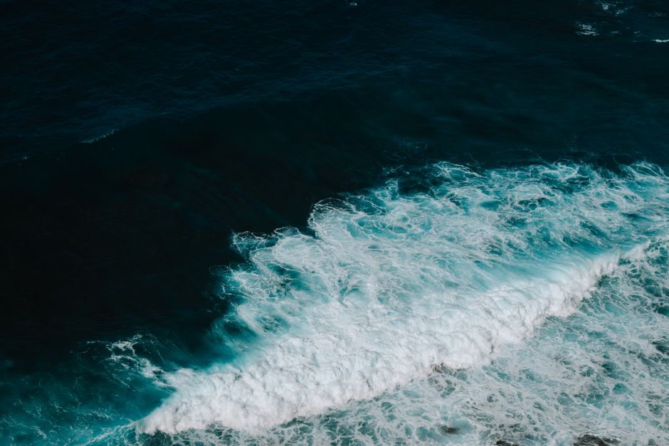 Stunning high-angle view of ocean waves crashing, showcasing nature's powerful beauty.