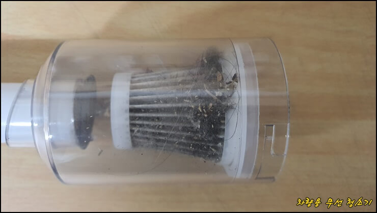 차량용 무선청소기로 먼지와 쓰레기를 흡입한 모습