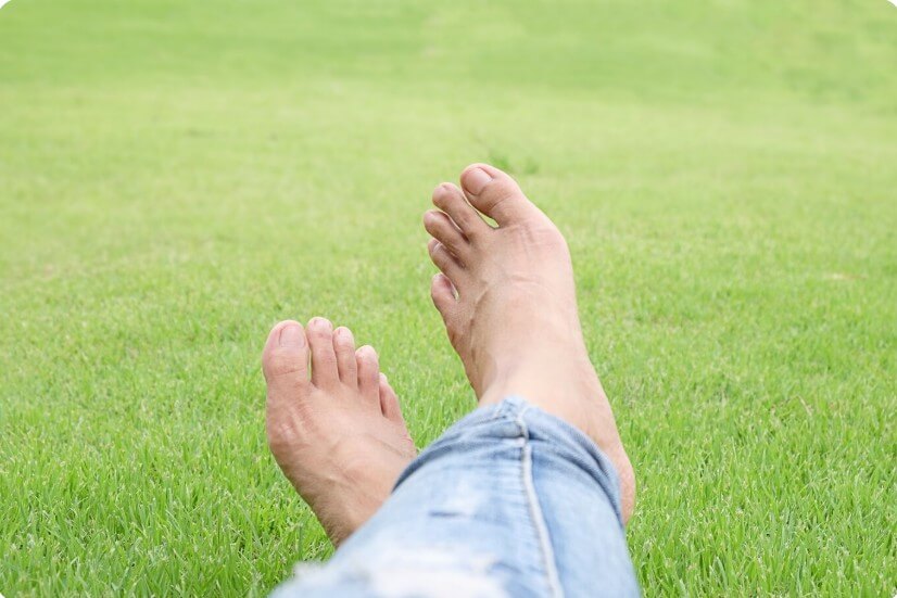 풀 숲에 앉아 있는 남성의 발