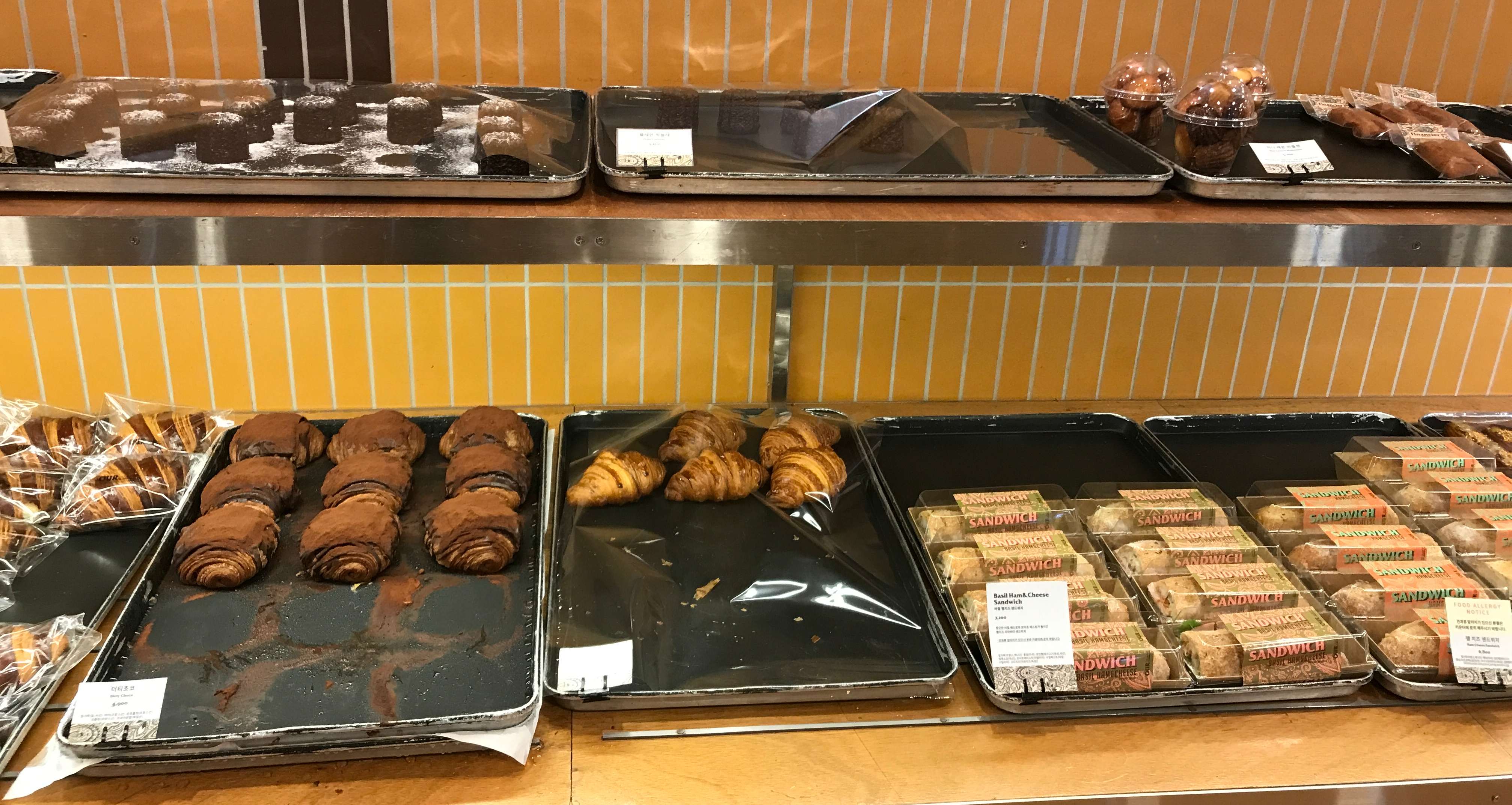 진열대에 크루아상, 까눌레 등 다양한 빵이 있습니다.