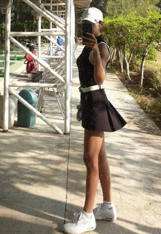 골프 연습 장소에서 흰색 운동화 브라운 원피스 입고 셀카를 찍는 모습