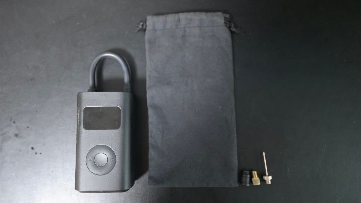 샤오미 공기주입기의 구성품. 본체, 충전 케이블, 노즐 팁, 파우치가 함께 정리된 모습.