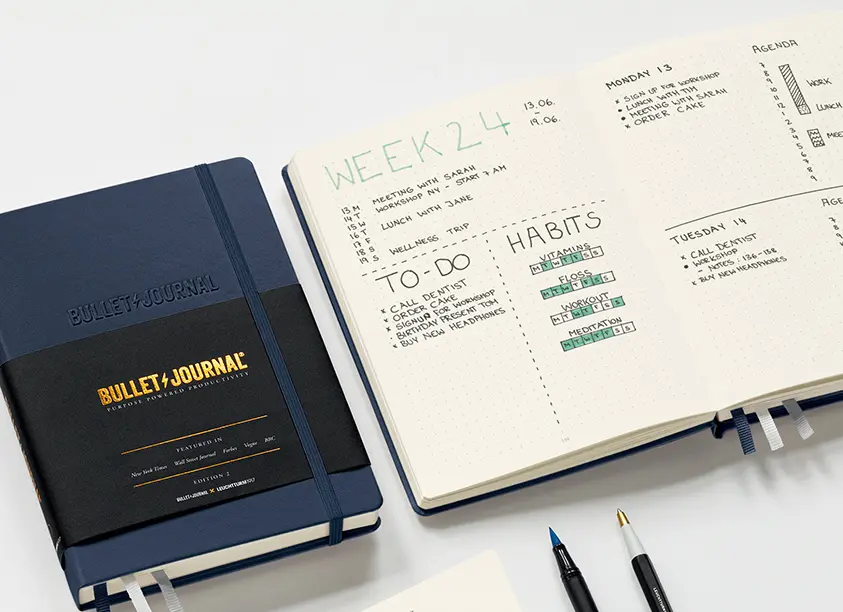 로이텀-다이어리가-책상-위에-놓여있으며-한-권은-펼쳐져-있는-모습