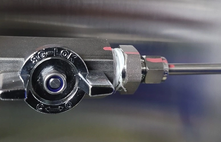 스탠레스 로크벨브와 배관의 연결부분에 적색선이 그어져 있다