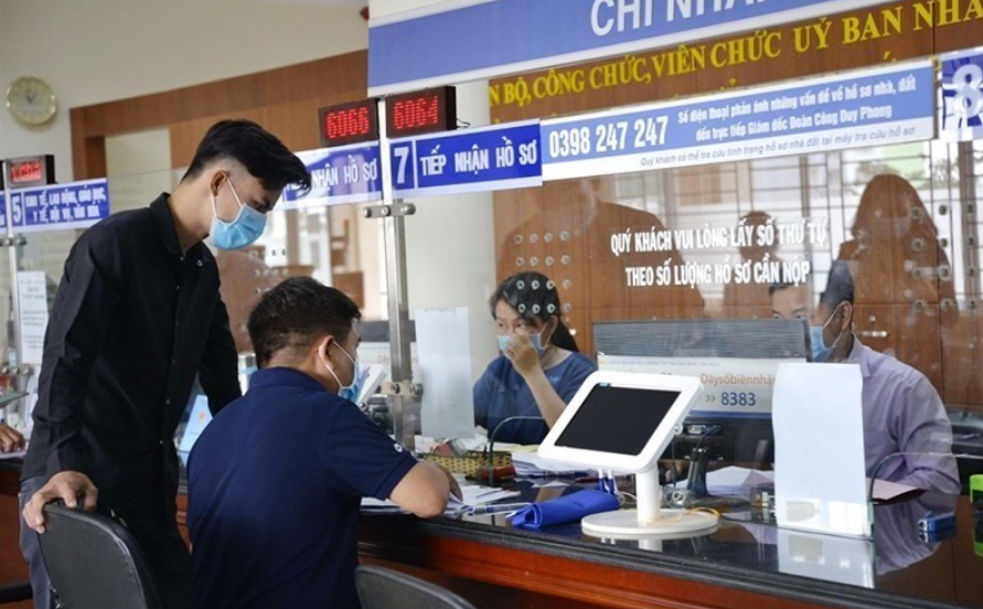 서류를 작성하는 시민과 서류를 받아 업무처리하는 베트남 공무원