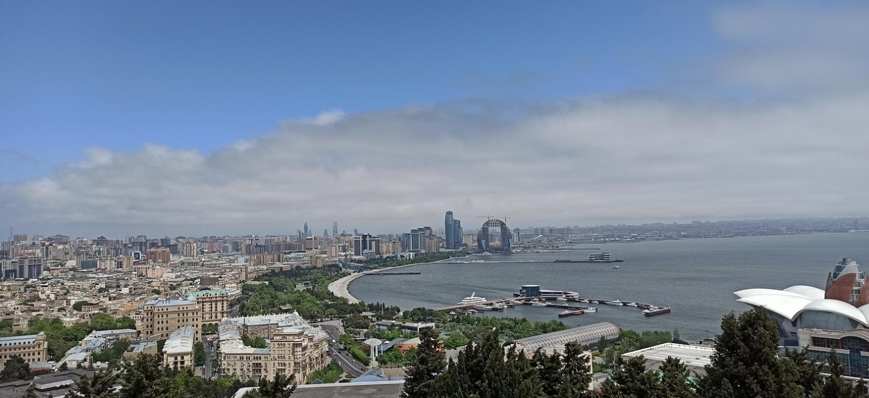 카스피해 해안선을 따라 펼쳐진 바쿠 불바르 산책로와 초승달 모양의 크레센트 호텔, 현대적인 마천루가 어우러진 도심 전경