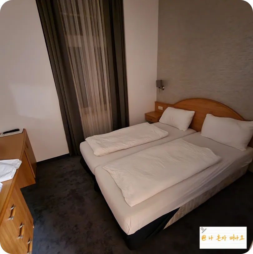 침대-두개와-테이블-있는-호텔방