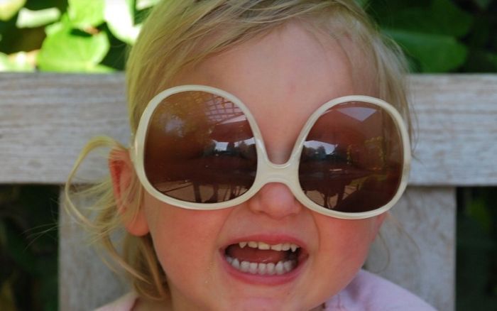 어린여자 아이가 선글라스를 끼고 있는 모습
