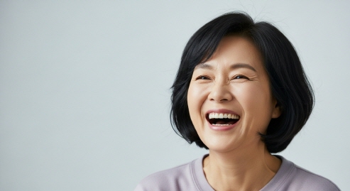 중년 여성이 드라마를 보며 웃는 모습