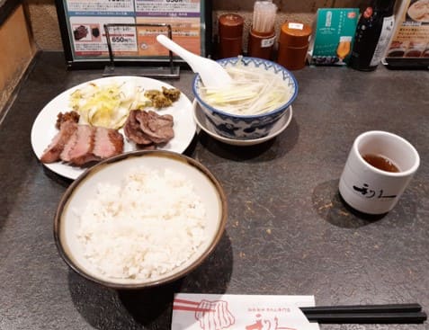 카운터 위에 밥과 고기 그리고 국과 물이 올려져 있다.