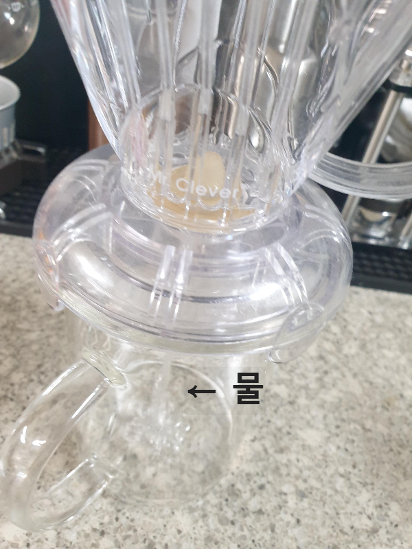 드리퍼 위에 올려진 미스터 클래버. 물이 아래로 떨어지고 있다.