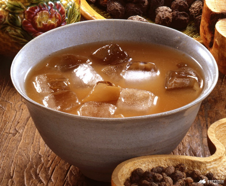 얼음과 각종 한약재를 갈아서 만든 제호탕을 가득 담은 사기그릇을 나무 테이블 위에 놓아두고 주변에 한약재를 조금씩 두고 찍은 사진