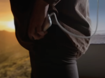 애플 비전 프로의 전원(배터리)를 손에 쥐고 있는 사용자의 모습