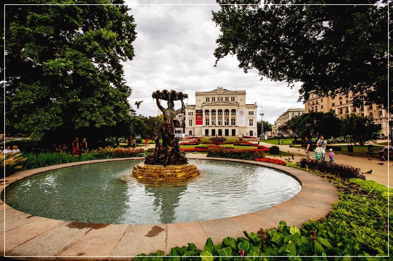 리가의 공원의 분수대 옆에서 휴식을 즐기는 가족