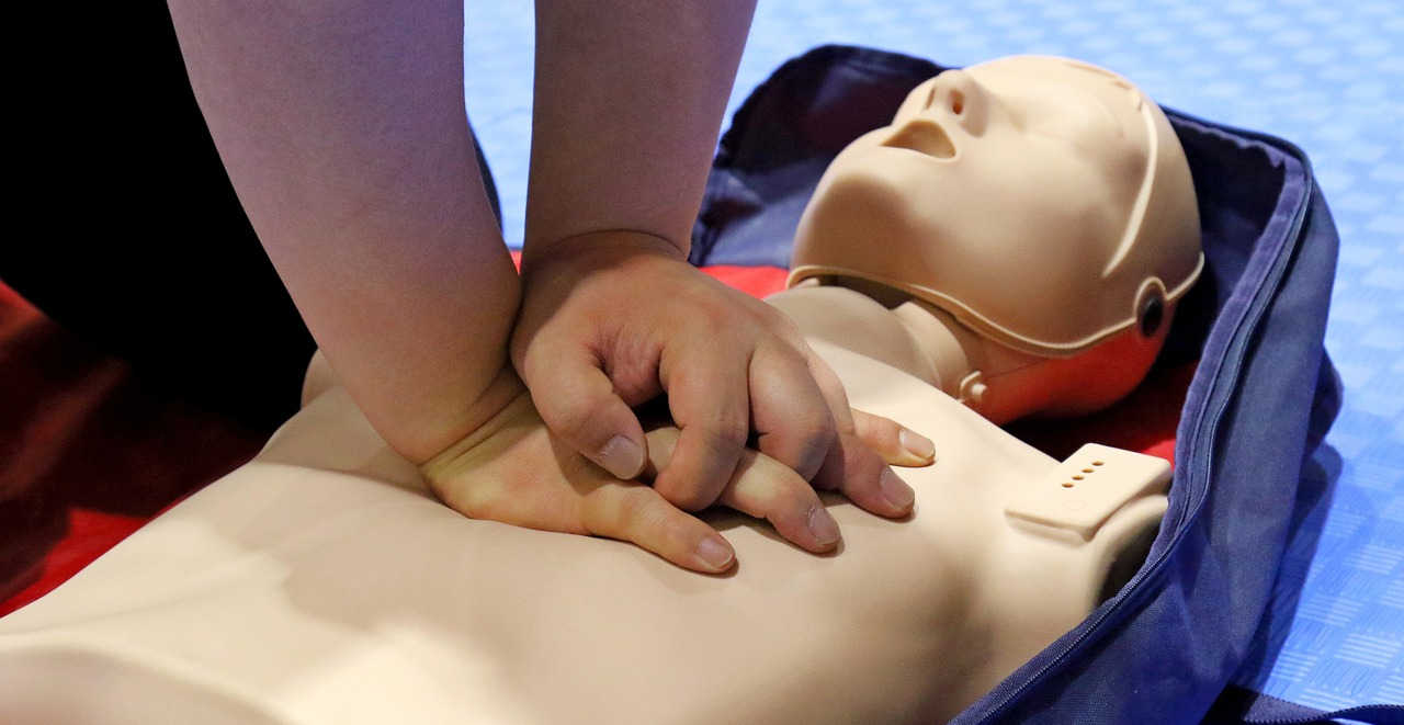 사람 모형에 심폐소생술을 연습하는 모습