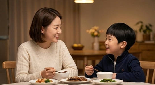 엄마와 아이가 마주 앉아 이야기를 나누는 따뜻한 저녁 식탁 장면