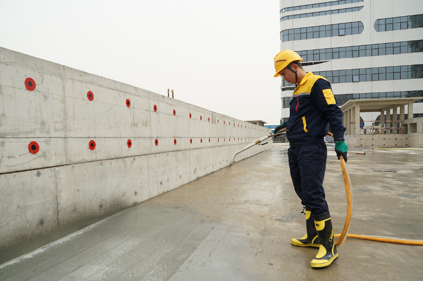 방수 스프레이 : 한 남성이 옥상에 방수 스프레이를 뿌리고 있다